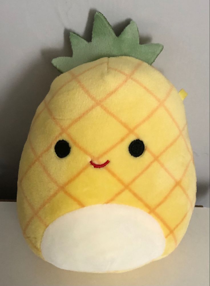 a yellow stuffed toy with a green pineapple on it's head