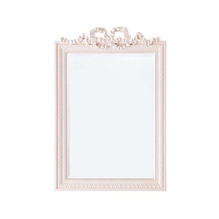 a white framed mirror with flowers on the frame and an empty paper in front of it