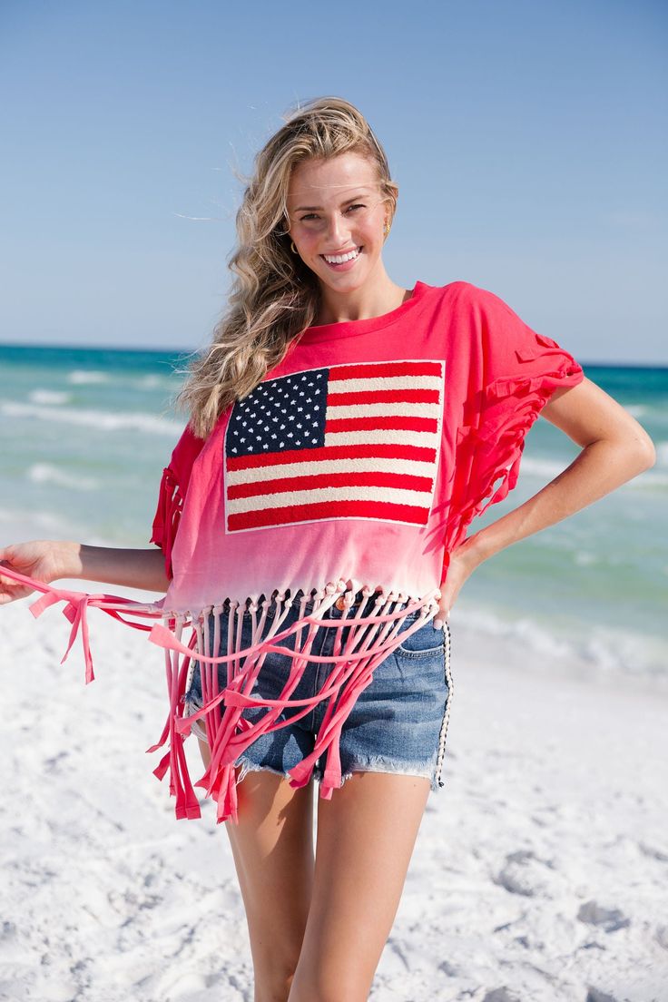 The LIBERTY TIE DYE FRINGE TEE is the perfect summertime look. Oversized for added comfort, this tee features lightweight fringe and tie-dye colors in both red and navy. Add the perfect touch to your 4th of July outfit with this festive and stylish look. All orders are currently shipping within 14 business days. To receive item quicker, expedited shipping is available at checkout. American Flag Print Cotton Top For Beach, Short Sleeve Tops For 4th Of July Vacation, Summer Tops For 4th Of July Vacation, Summer Cotton T-shirt With Fringe, Summer Tops For Vacation And 4th Of July, Vacation Tops For 4th Of July With Short Sleeves, Summer Fringe Cotton T-shirt, American Flag Print Summer Beach Top, Summer Cotton Fringe T-shirt