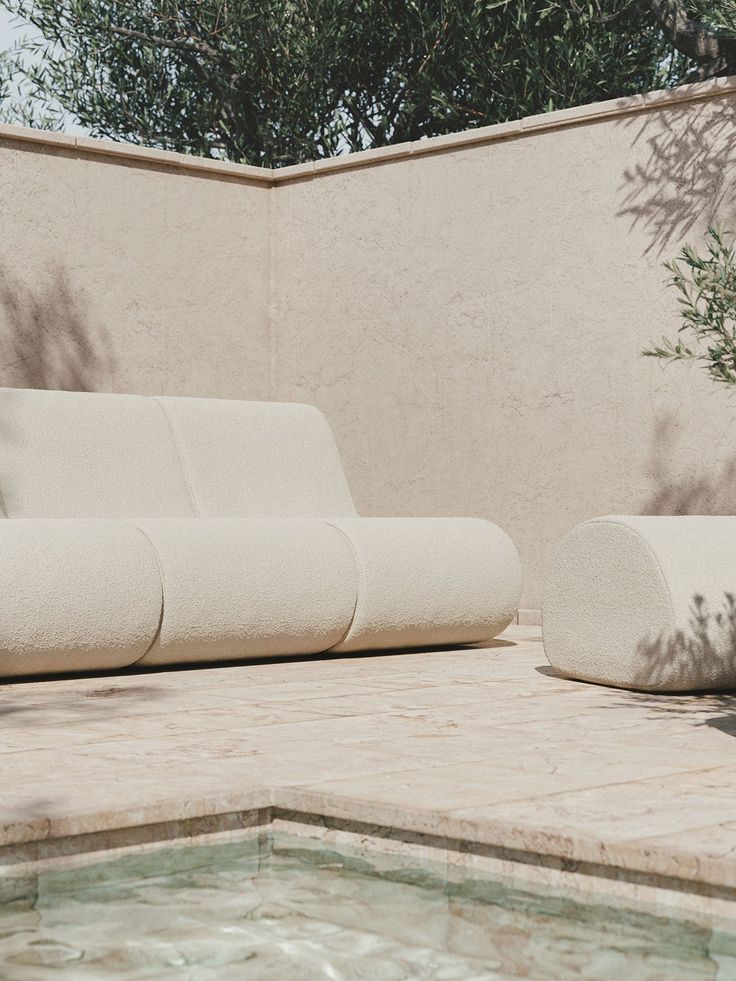 a white couch sitting next to a swimming pool