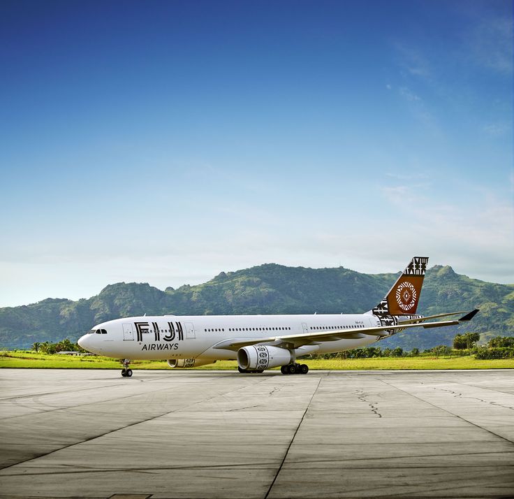 a large jetliner sitting on top of an airport tarmac under a blue sky