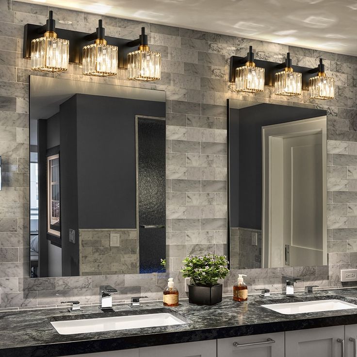 a bathroom with double sinks and two mirrors on the wall above them is decorated in gray marble