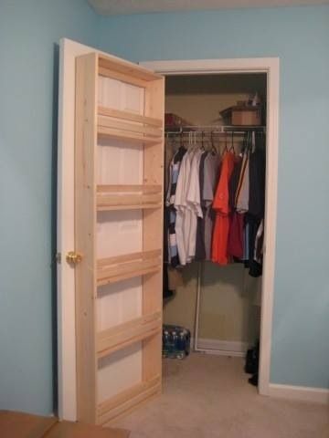 an open closet with clothes on hangers and shoes hanging from the door to the other side