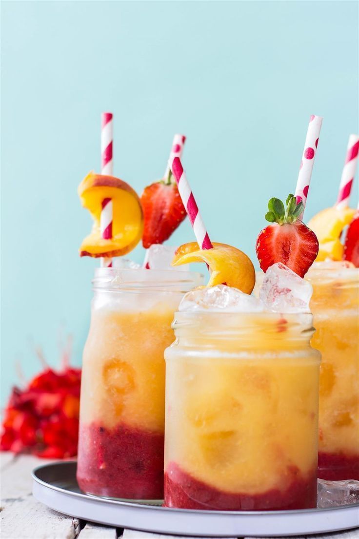 three mason jars filled with fruit and topped with strawberries, pineapples and orange slices