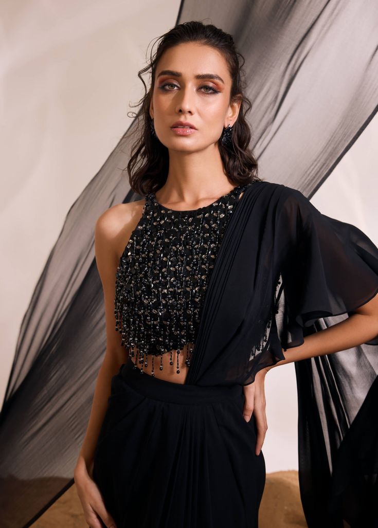 Make a bold statement with hailey sari set, a fusion of modern sophistication and traditional charm. The ensemble includes a heavily embellished backless blouse with elegant tassel accents, paired with a concept drape sari for an enchanting and distinct look. Drape Sari, Sharara Gharara, Nyc Studio, Drape Saree, Black Drapes, Backless Blouse, Soho Nyc, Nehru Jackets, Indian Couture