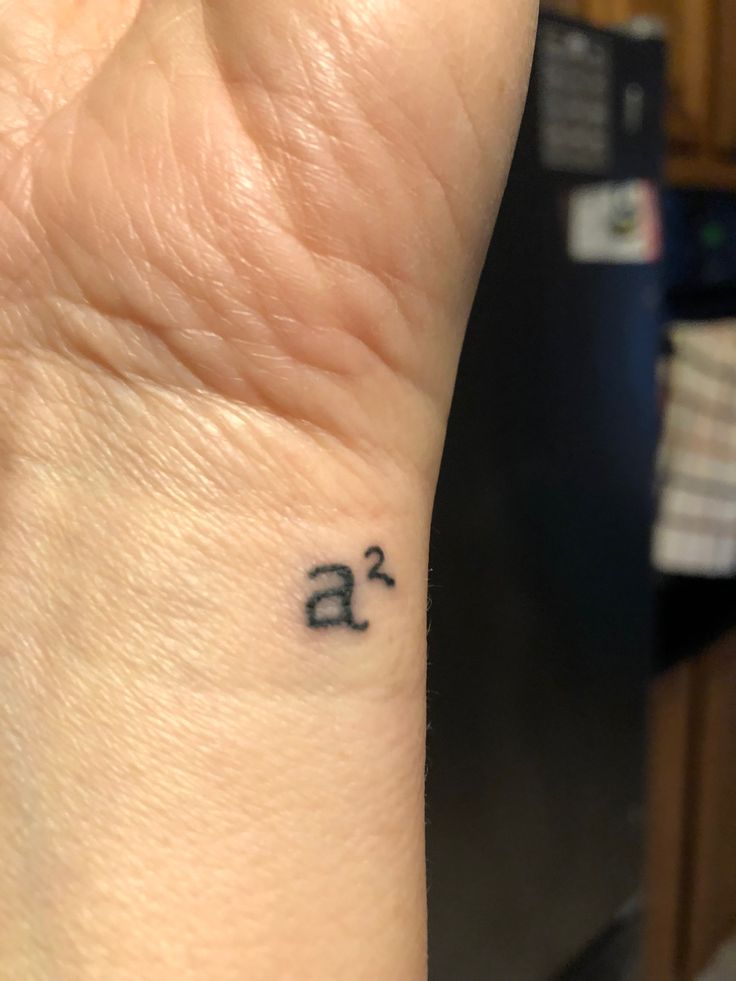 a small wrist tattoo with the letter a on it