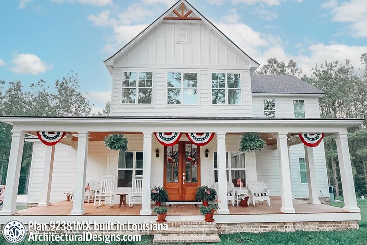 a white house with red, white and blue decorations on it's front porch