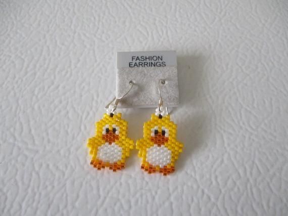 a pair of yellow and white beaded earrings with a rubber ducky on it