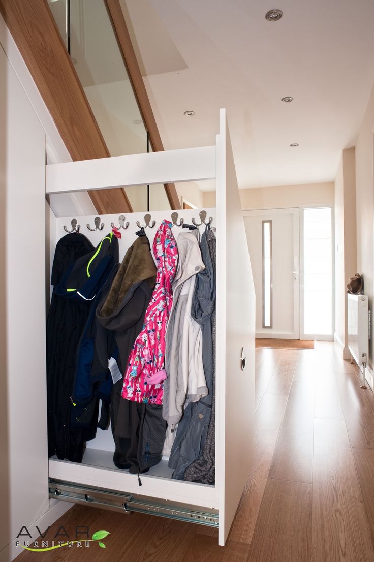 an open closet with clothes hanging on hooks