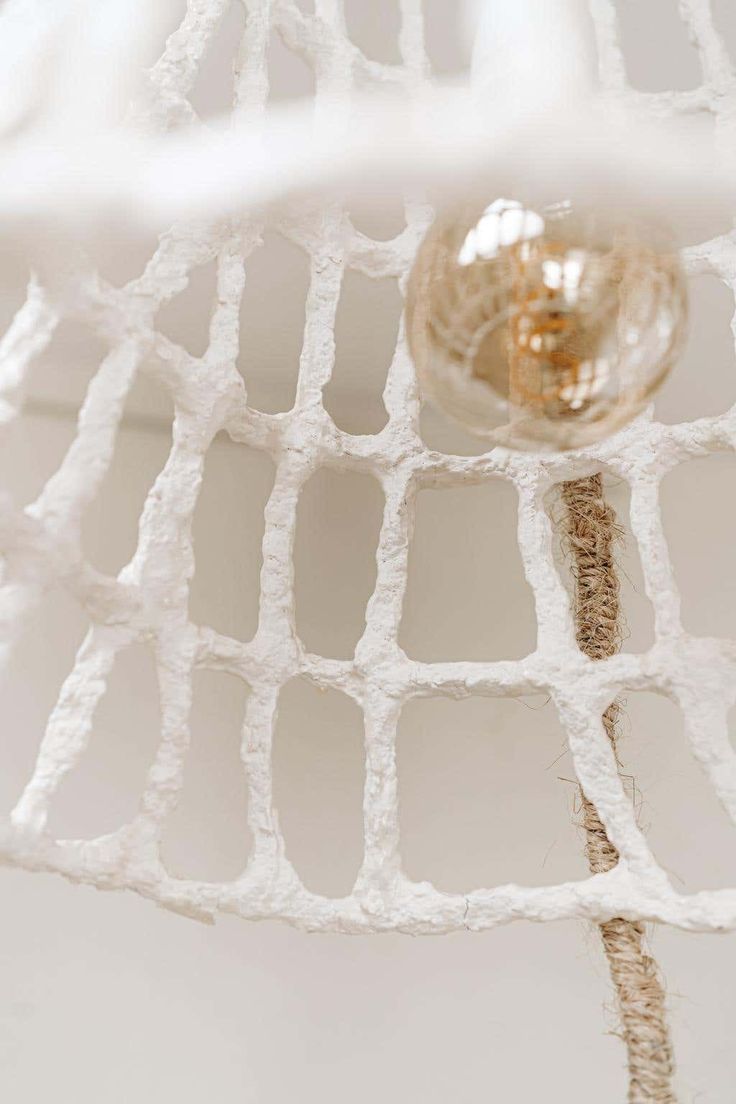 a close up view of a glass ball on a white netted ceiling light fixture