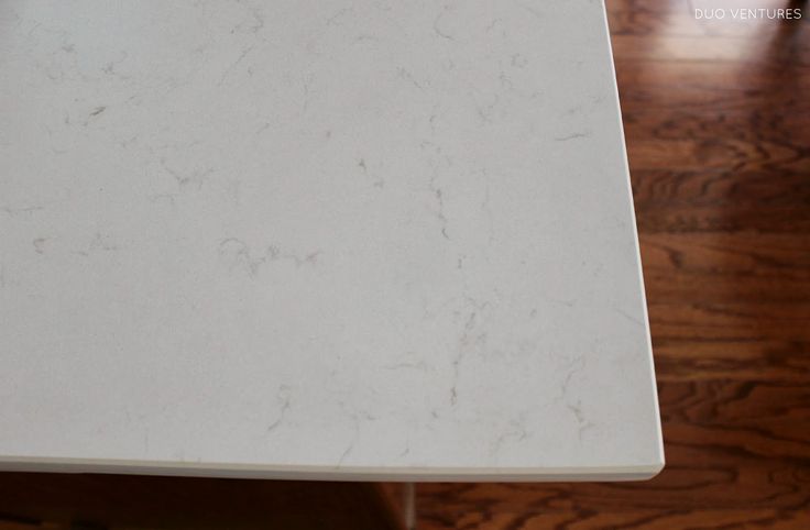 a white marble table top on a wooden floor