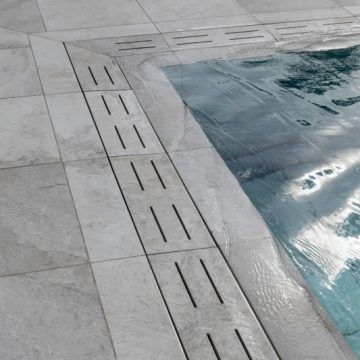 an empty swimming pool in the middle of a tiled floor