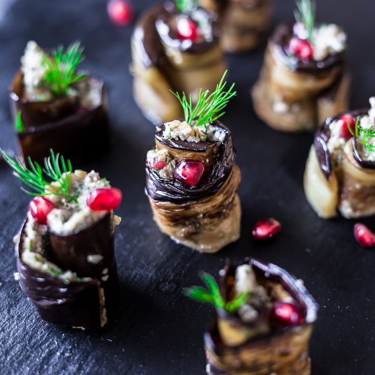 small desserts with chocolate and cranberry toppings are arranged on a black surface