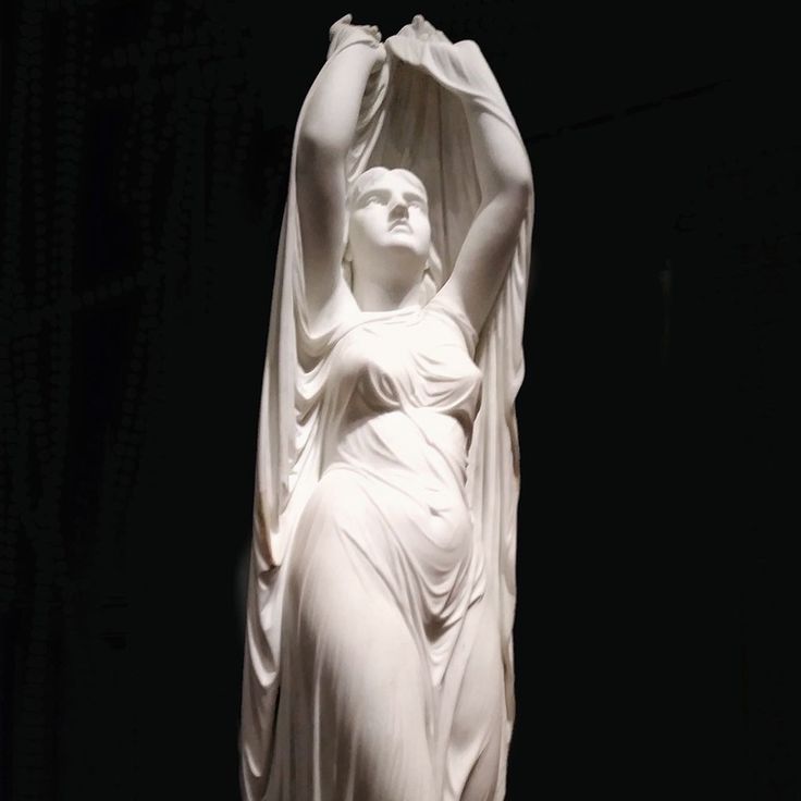 the statue is white and has a woman's body draped over it with her hands in the air