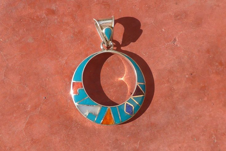 This beautiful Black Inca Calendar jewelry set is made by hand by the beautiful Quechua people of the Peruvian Andes. It is handmade in 950 silver, Lapiz Lazuli Stone and Turquoise Stone by a local family of jewelry artesians. Best quality artisan work PENDANT : Weight : 6.1 gr Diameter : 3.1 cm Height with the hook :4.5 cm EARRINGS: Weight: 11 gr Diameter : 3.1 cm Height with the hook : 5.3 cm Southwestern Jewelry With Inlay For Gifts, Southwestern Style Jewelry With Inlay For Gift, Southwestern Style Inlay Jewelry As Gift, Artisan Sterling Silver Jewelry With Inlay, Sterling Silver Artisan Jewelry With Inlay, Artisan Sterling Silver Inlay Jewelry, Southwestern Style Hallmarked Round Jewelry, Handmade Southwestern Round Jewelry, Handmade Southwestern Style Round Jewelry