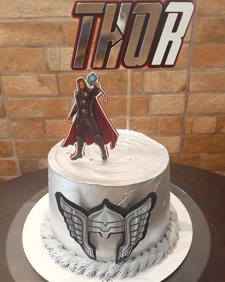 a thor birthday cake with the name thor on top and an image of thor standing behind it