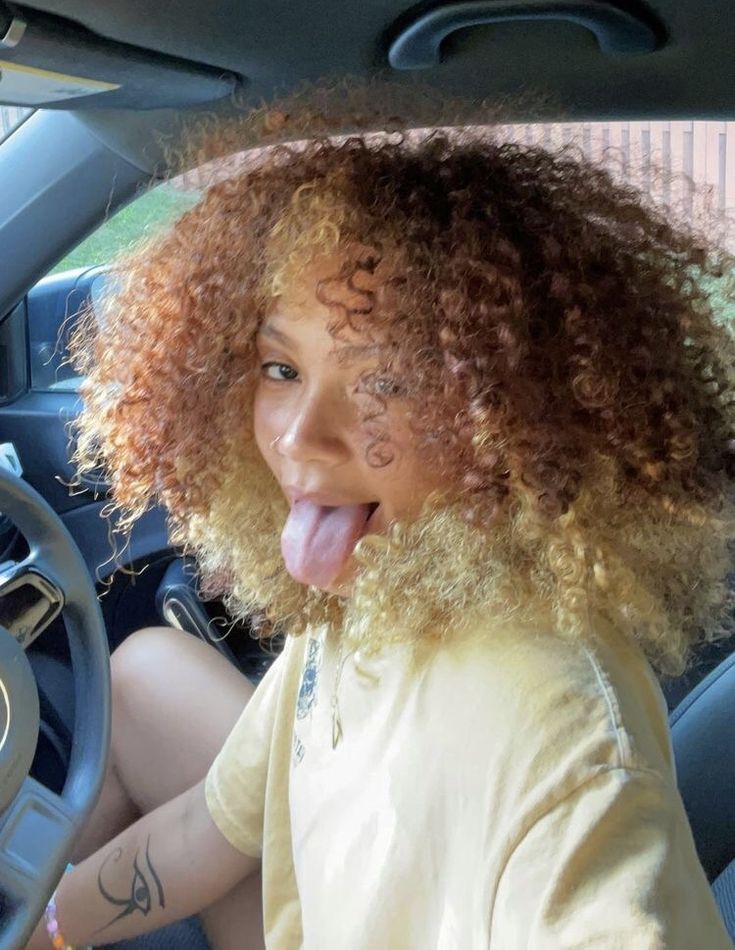 a woman sticking her tongue out while driving