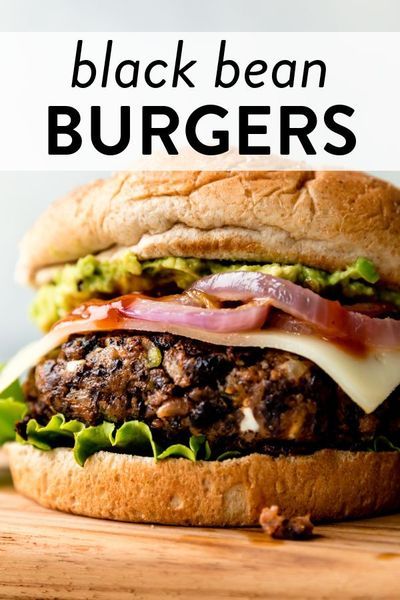 a close up of a burger on a wooden table with the words black bean burgers