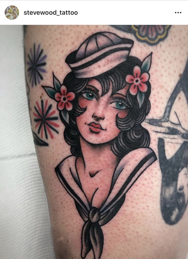 an old school sailor girl tattoo on the thigh