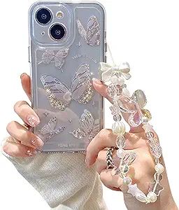 a woman is holding up her phone case with butterflies on it and pearls attached to the back