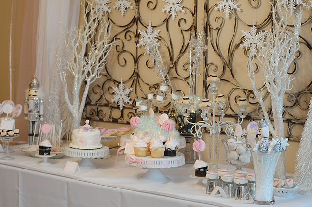 a table topped with cakes and cupcakes on top of a white table cloth