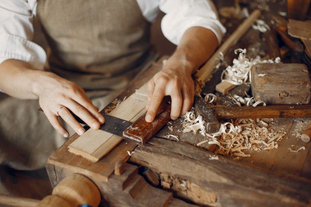 a man in an apron working on woodworking