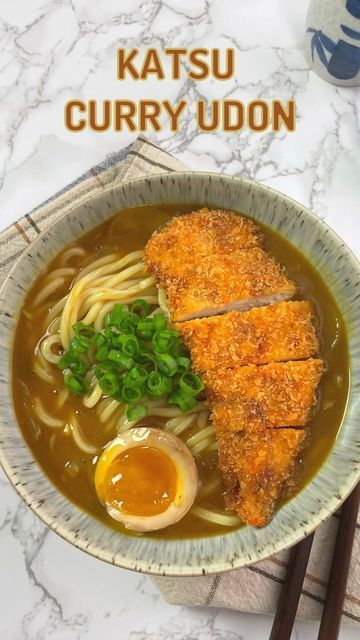 a bowl filled with noodles and meat next to chopsticks on top of a table