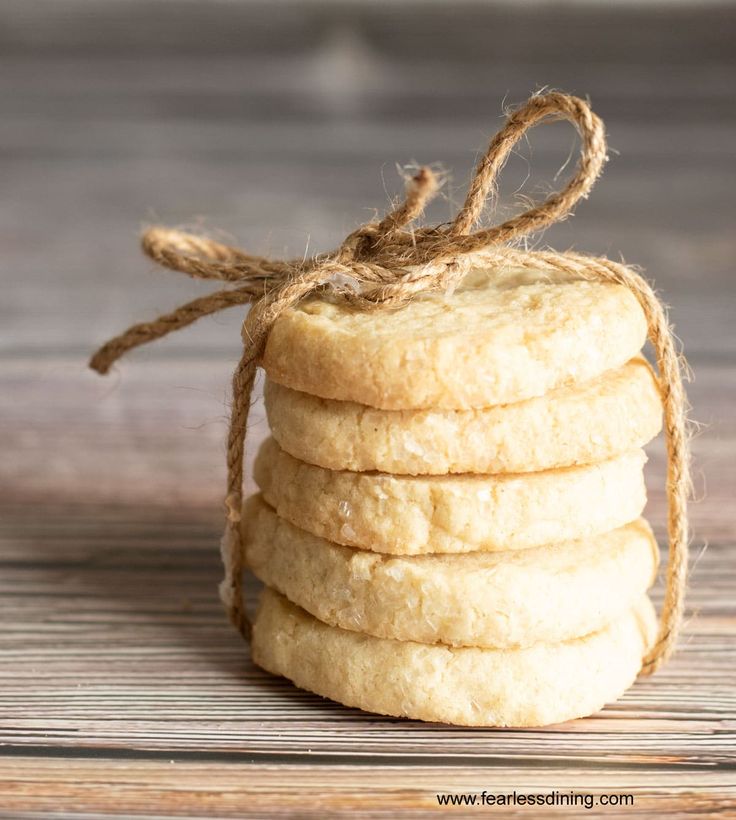 a stack of shortbread cookies wrapped in twine on top of a wooden table