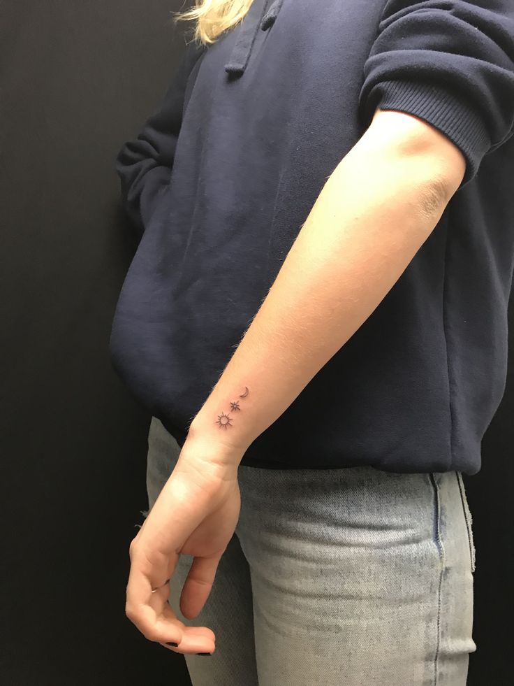 a woman with a small tattoo on her left arm and the word love written in cursive writing