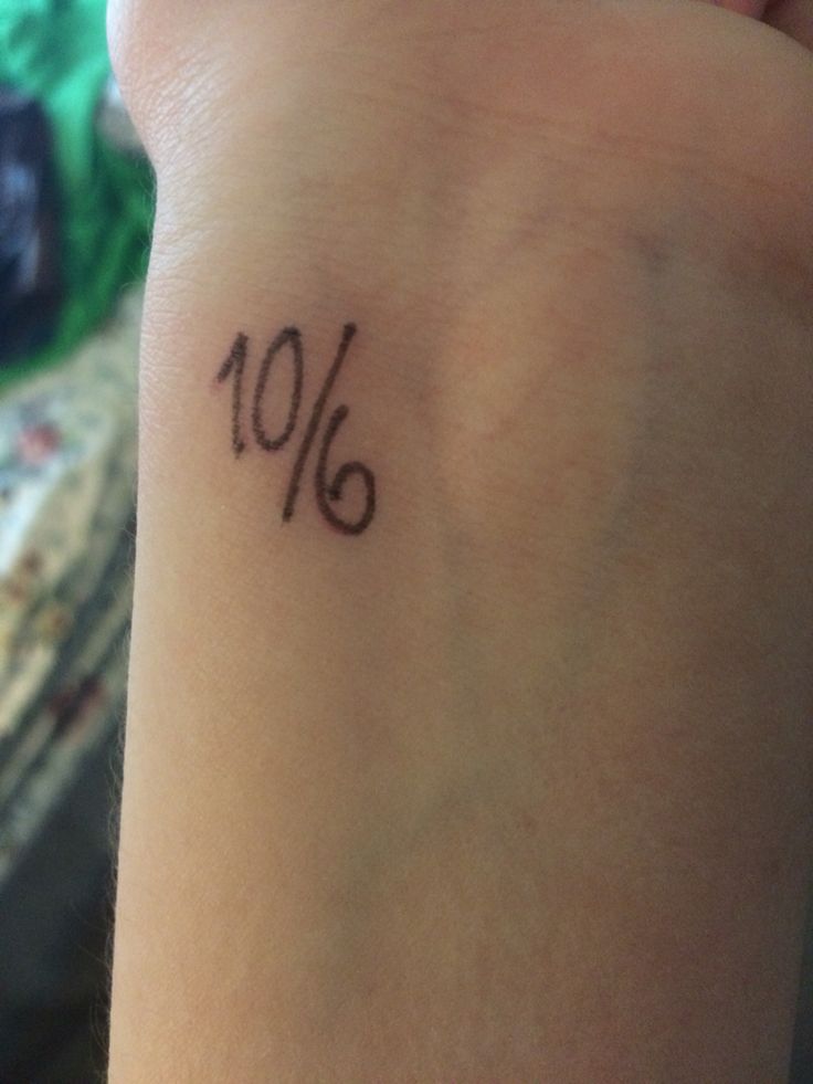 a person with a tattoo on their wrist that reads 10 %