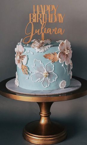 a blue birthday cake with flowers on it