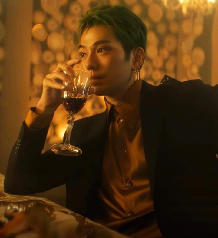 a man sitting at a table with a glass of wine