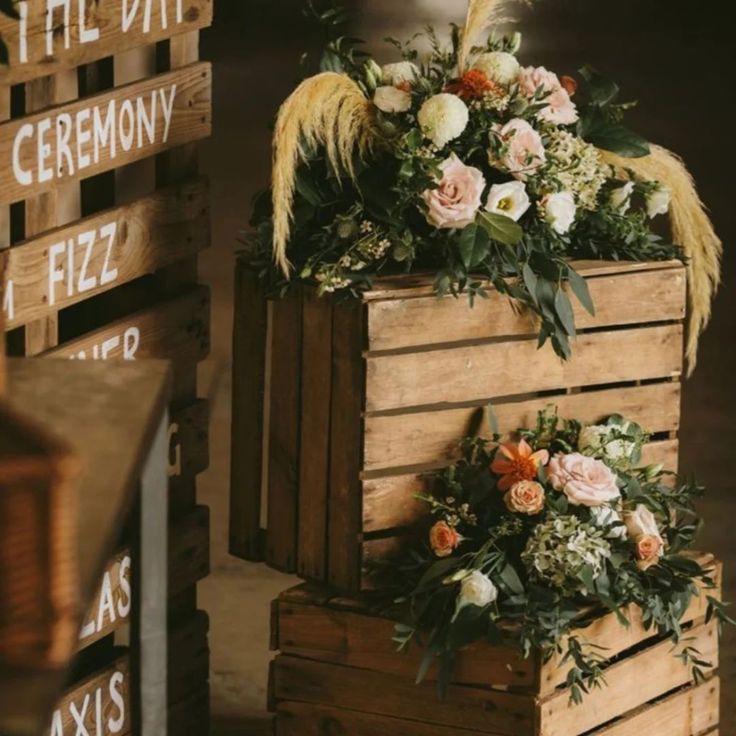 two wooden crates with flowers and feathers on them