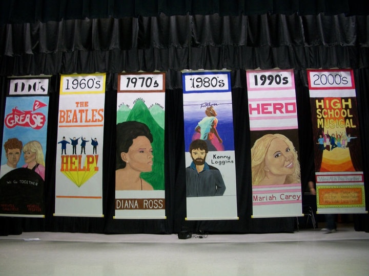 a row of posters on a stage in front of a black curtain