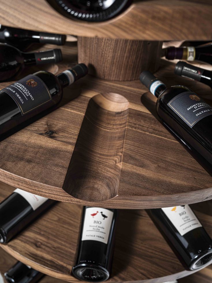 three tiered wine rack holding several bottles of wine on top of a wooden table