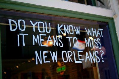 a window with writing on it that says do you know what it means to miss new orleans?