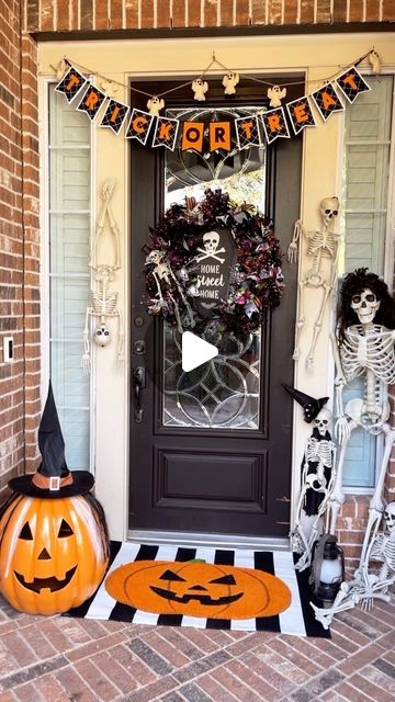 a front door decorated for halloween with pumpkins and skeletons