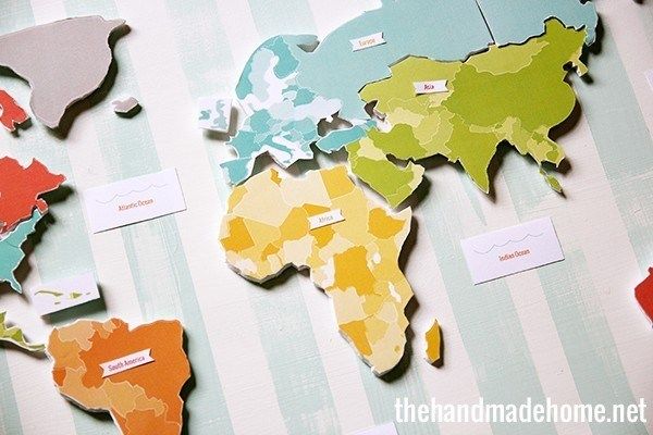 the world map is made out of paper and cut into smaller pieces with name tags on them