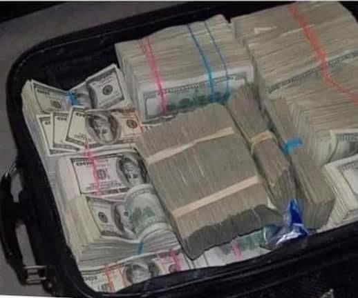 a suitcase filled with money sitting on top of a floor