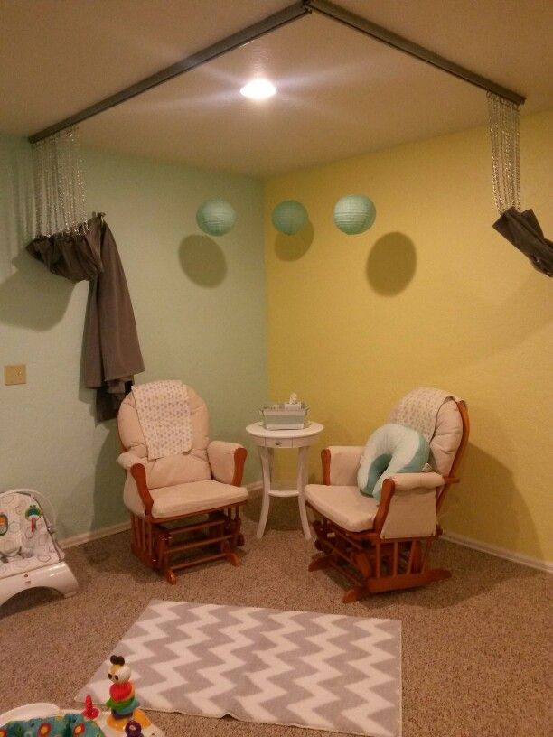 a baby's room with two rocking chairs, a table and other toys on the floor