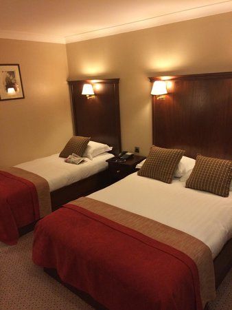 two beds in a hotel room with lamps on