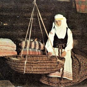 an old photo of a woman standing next to a basket