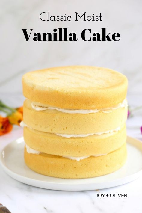 a stack of vanilla cake sitting on top of a white plate with flowers in the background