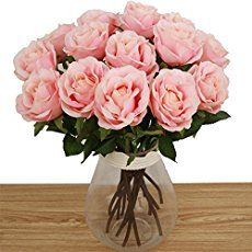 a vase filled with pink roses on top of a wooden table