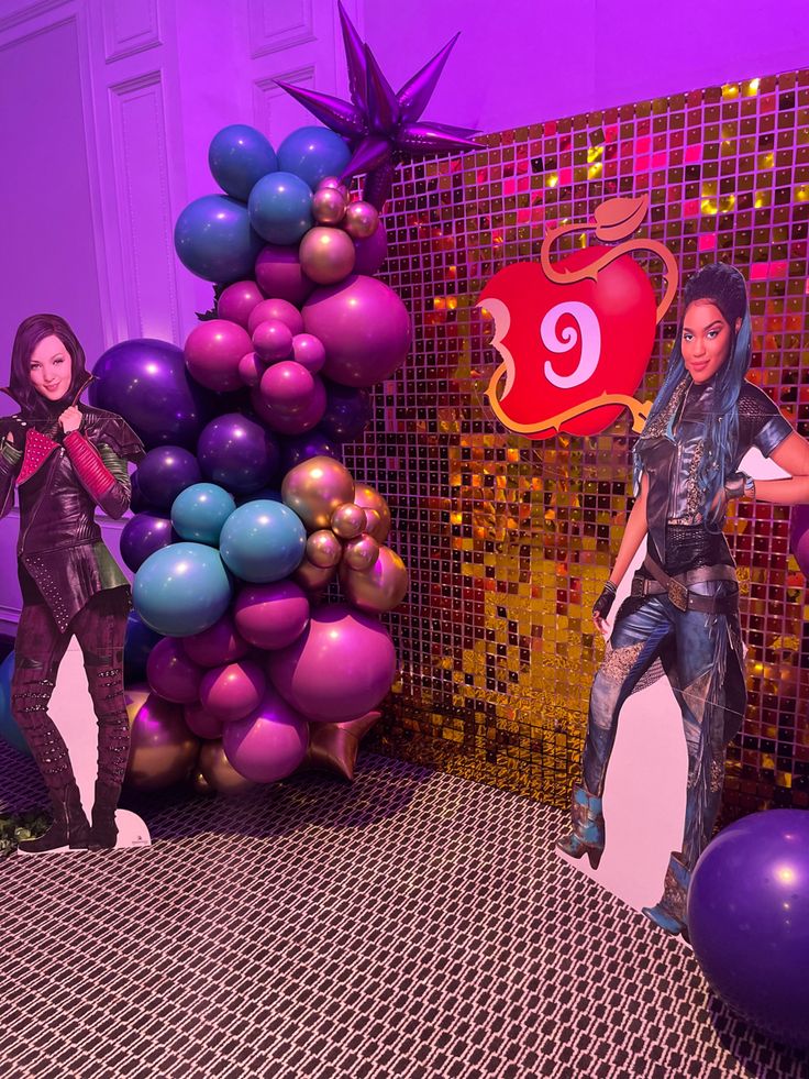 two barbie dolls are posed in front of balloons and a wall with an image of michael jackson