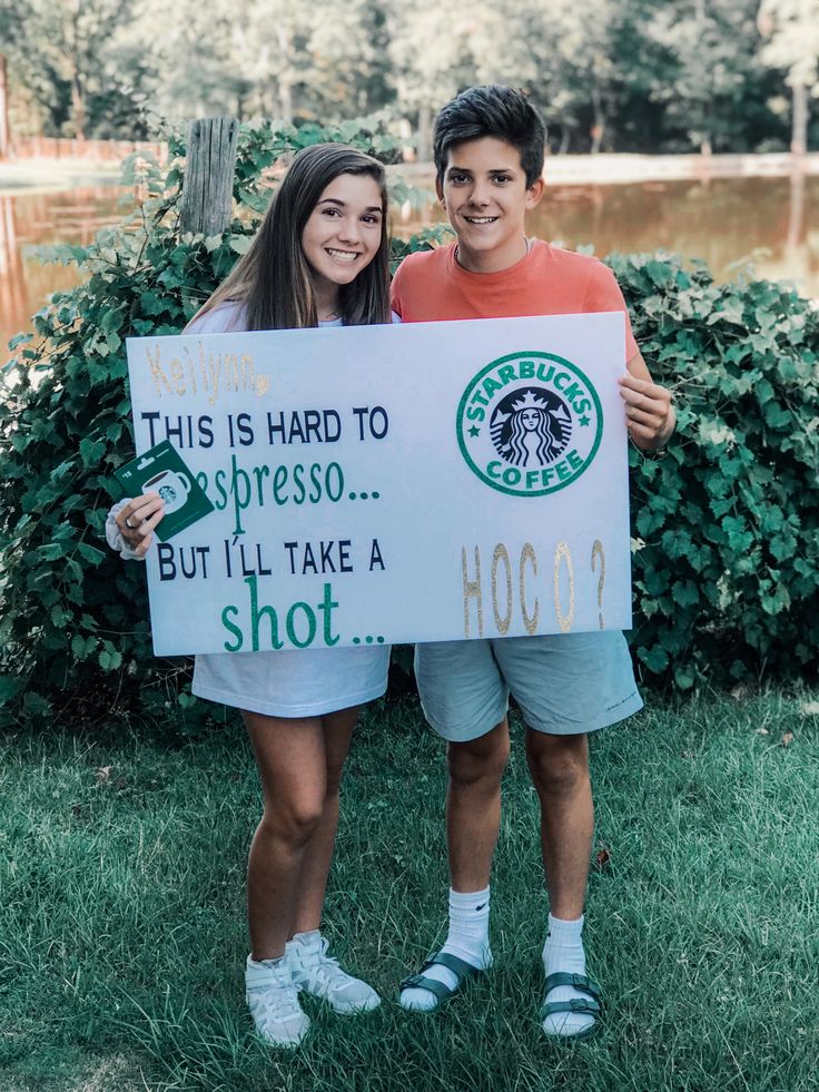 two people holding up a sign that says, this is hard to espresso but i'll take a shot