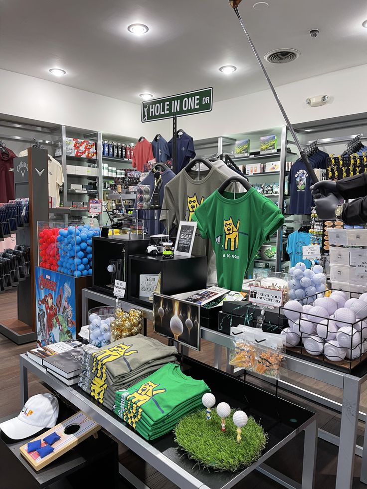 there are many items on the table in this store, including t - shirts and balloons