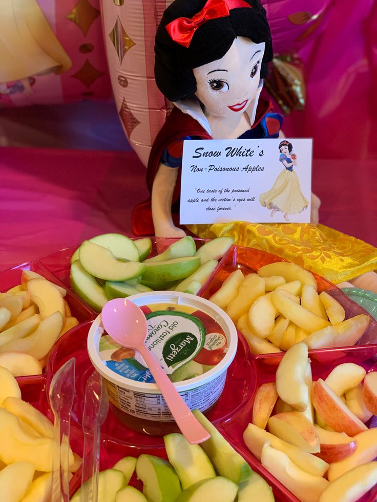 an assortment of apples and other fruits on a table with a sign that says snow white's