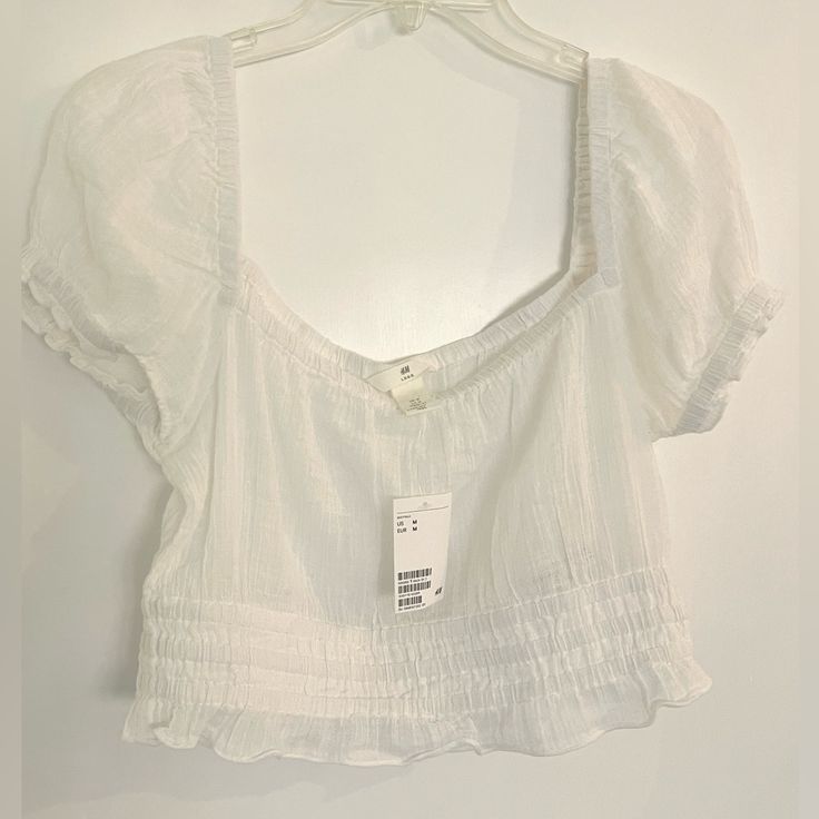 Short Top In Crinkled, Woven Sheer See-Through Cotton Fabric. Square Neckline With Covered Elastic, Elastic Over Shoulders, And Short Puff Sleeves With Elasticized Cuffs. Smocked Lower Section With Ruffle At Hem. 100% Cotton Casual Summer Tops With Crinkle Texture, Fitted Crinkle Texture Blouse For Summer, Fitted Crinkle Texture Tops For Spring, Summer Crinkle Texture Blouse For Day Out, Trendy H&m Summer Blouse, Fitted H&m Top For Beach, White Crinkle Texture Top For Summer, H&m Casual Summer Blouse, H&m Summer Casual Blouse