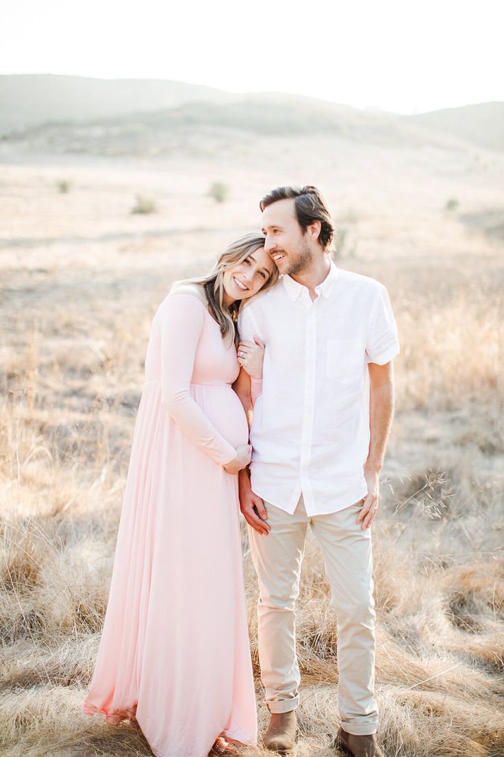 a man and woman standing in the middle of a field